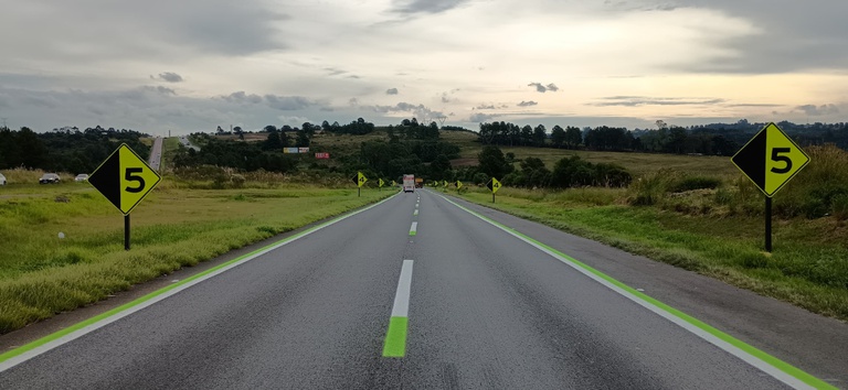 Foto mostrando rodovia com placas e sinalização horizontal pintadas