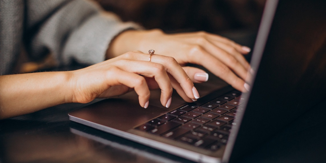 Mãos femininas digitando em um notebook