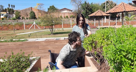 Imagem: Vania guia usuário de cadeira de rodas pelo 'caminho das mãos' (Arquivo pessoal)