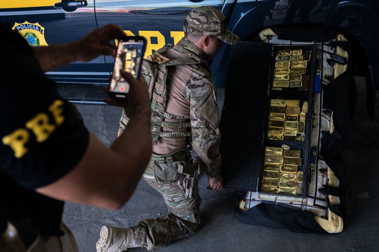 Agentes da Polícia Rodoviária Federal inspecionam barras de ouro apreendidas