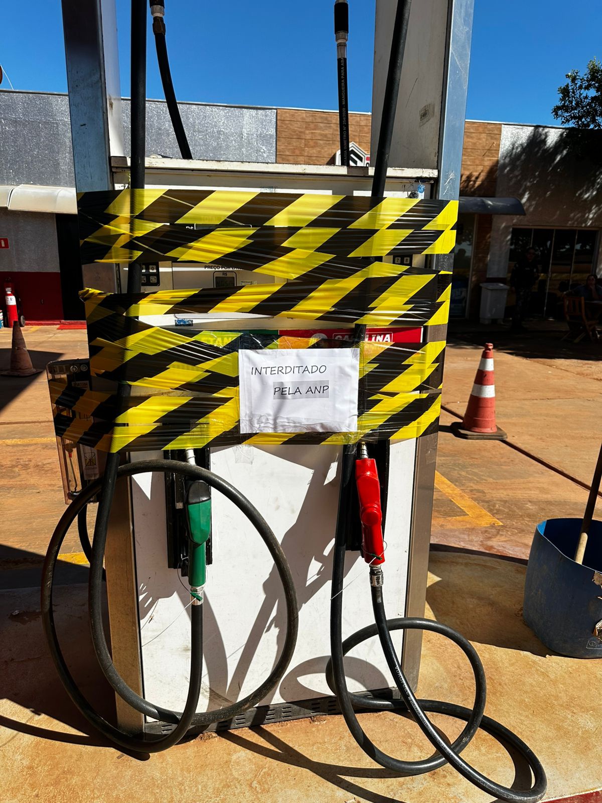 Bomba de gasolina embulhada em fita zebrada de interdição