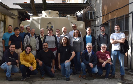 Membros da colaboração SWGO em frente ao detector Cherenkov protótipo desenvolvido pelo CBPF para o projeto. Quando concluído, o sítio de Pampa La Bola, no Chile, deverá receber até 5 mil unidades de detectores Cherenkov, que irão compor o futuro observatório, e ficarão espalhados por uma área de cerca de 1 km2. Créditos da Imagem: Tatiana Azzi, CBPF/NCS.