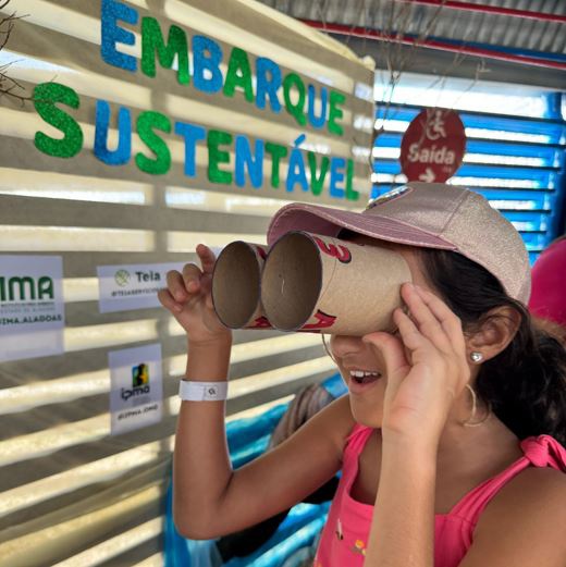 Crianças se divertem com brinquedos feitos em materiais recicláveis