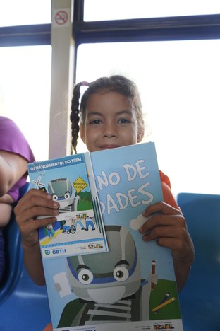 Criança com material educativo sobre segurança no trânsito