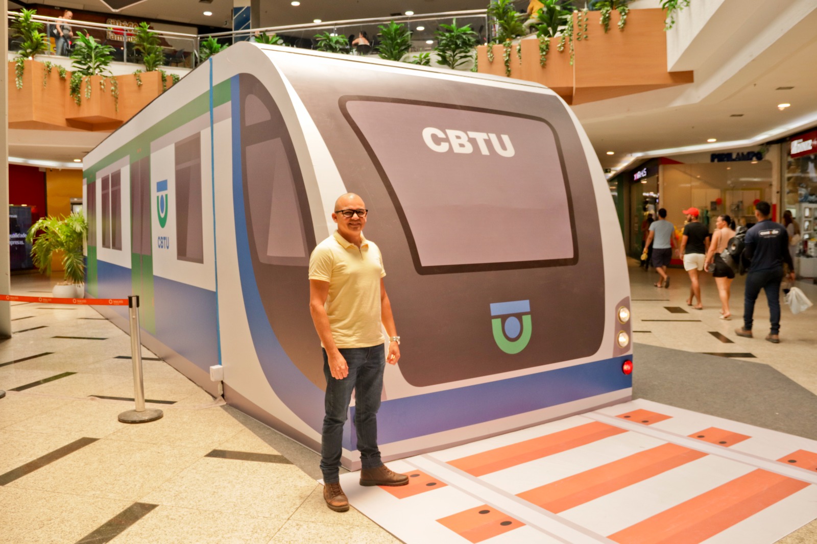 Empregado da CBTU em frente ao VLT da exposição fotográfica dos 40 anos da empresa em Maceió 