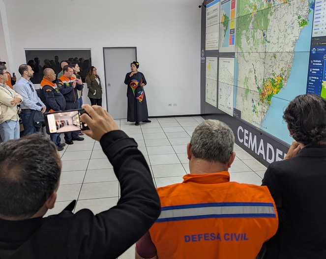 Regla Somoza, tecnologista do Cemaden, apresenta detalhes do funcionamento da Sala de Situação aos participantes da visita técnica.