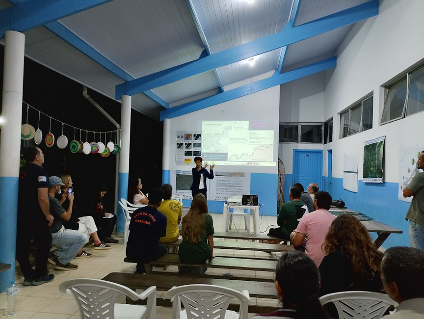 Foto 3 Oficina em Ubatumirim - Célia Regina de Gouveia Souza (IPA Geociências), apresentando sobre processos de erosão e inundação costeira no litoral norte de São Paulo.