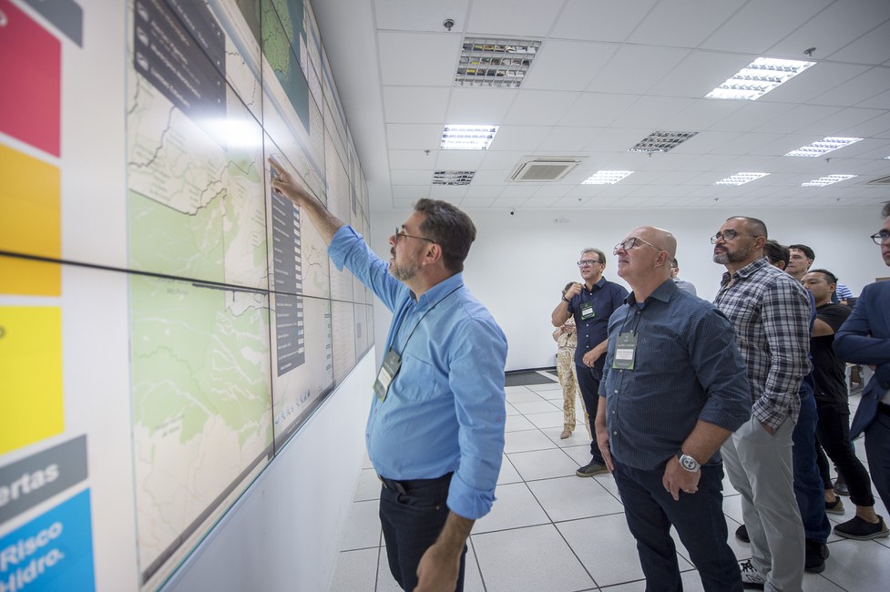 Representantes dos órgãos de controle e do judiciário observam informações nos telões da Sala de Situação do Cemaden