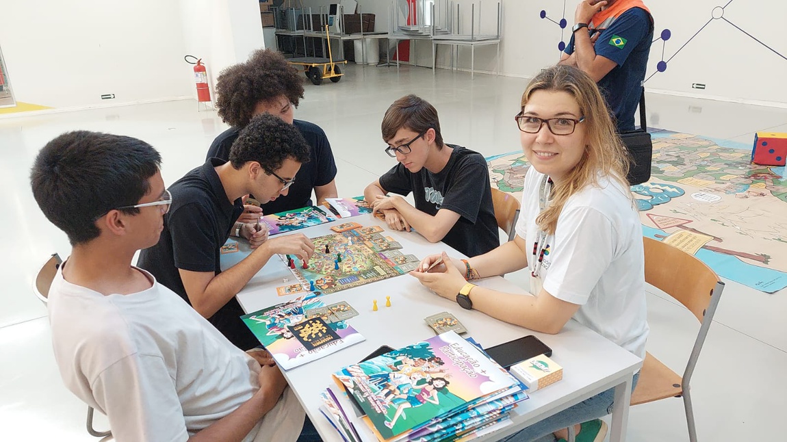 SNCT-2024 - Pesquisadora do Cemaden Educação orienta os estudantes do Ensino Médio no jogo de tabuleiro, durante a Oficina da programação da SNCT no Cemaden.