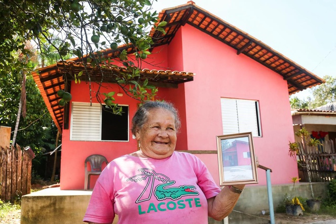 Na foto dona Petrúcia em frente a sua nova casa
