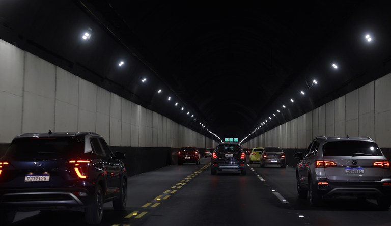 Na foto carros trafegam dentro de um túnel