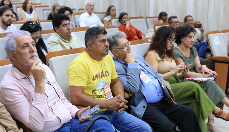 Grupo de pessoas sentadas assistindo palestra sobre o programa Minha Casa, Minha Vida.