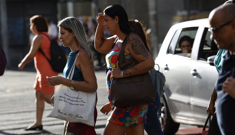 Na foto pessoas atravessando uma faixa de pedestres