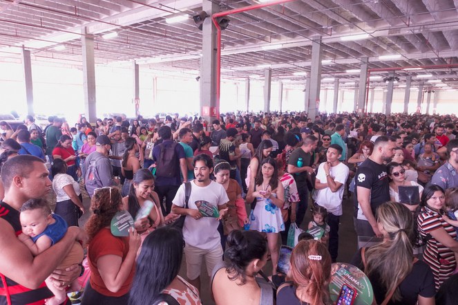 Na imagem há varias pessoas num auditório. 