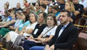 Grupo de pessoas sentadas num auditório assistindo uma palestra.