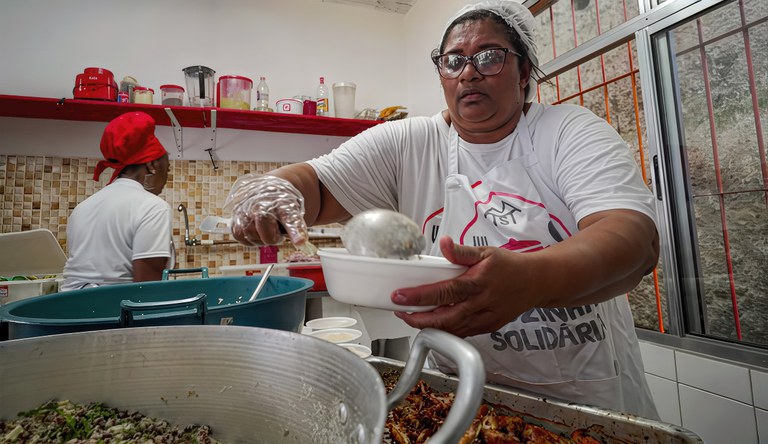 Duas mulheres preparando as marmitas do Cozinha Solidária