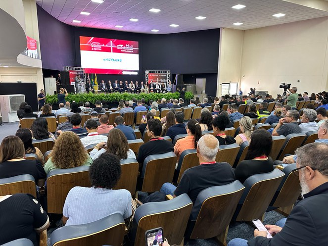 Na foto o publico de dezenas de pessoas acompanha o prununciamento dos palestrantes