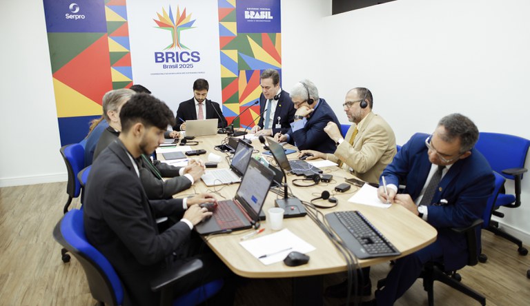 Na foto o grupo de trabalho reunido em uma mesa oval com nove pessoas