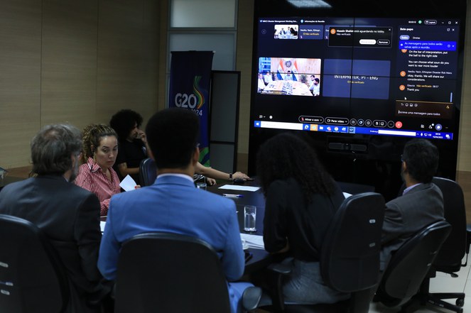 Na foto o secretário e demais participantes observam o telão