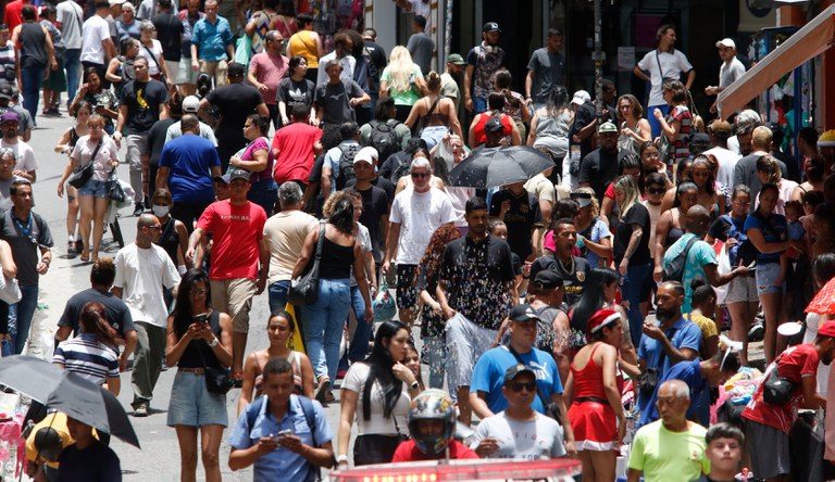 Pessoas andando numa rua movimentada.