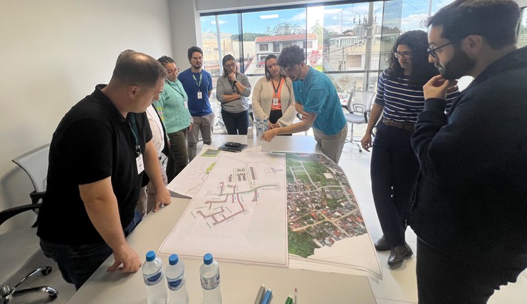 Grupo de pessoas olhando uma mapa de periferia de Curitiba.