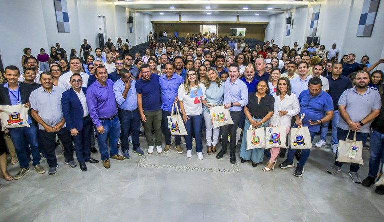 Grupo de pessoas em pé sorrindo para o fotógrafo
