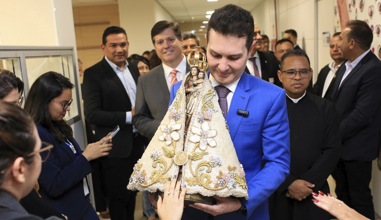 Na foto o ministro das cidades segurando a imagem de Nossa Senhora