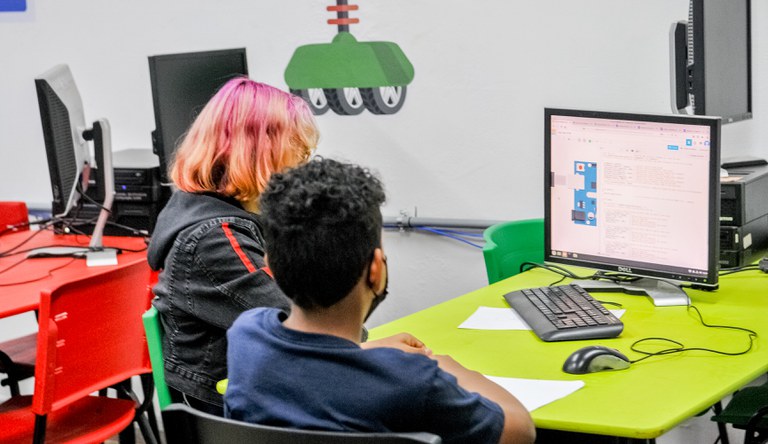 Duas pessoas sentadas em frente ao computador.