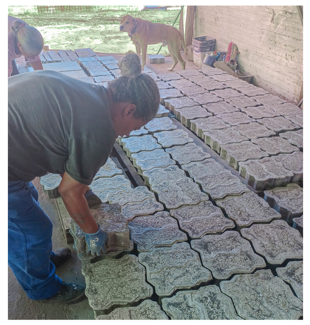 Na imagem duas mulheres colocando concreto numa obra do programa MCMV.