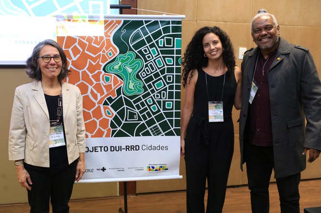 Na foto Marcel Santana ao lado do banner com outras duas pessoas