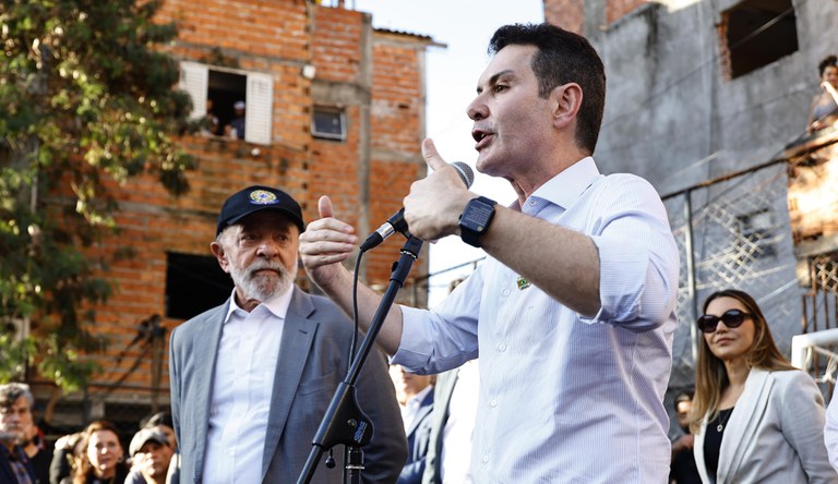 O ministro das cidades discursando sendo observado pelo presidente da república
