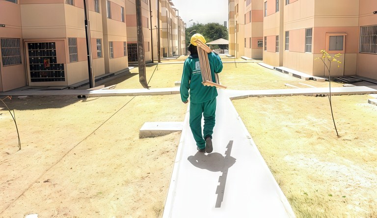 Trabalhador andando no conjunto habitacional do MCMV