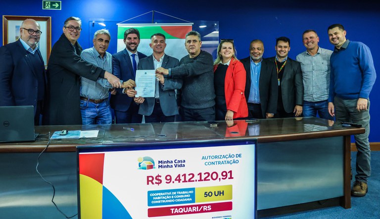 Na foto o secretário-executivo do Ministério das Cidades exibindo o documento junto a outras autoridades.