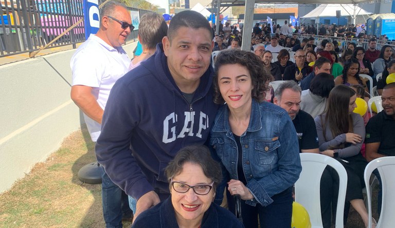 Na imagem mulher cadeirante acompanha filho no recebimento da casa p´rópria