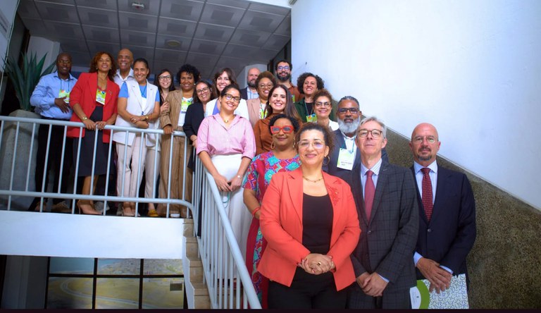 Na foto a equipe do MCid posa em uma escadaria em L