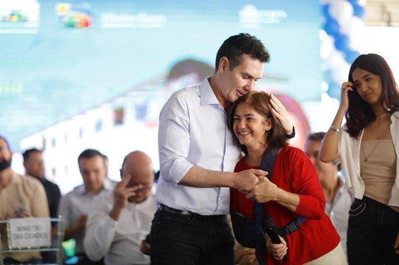 Ministro Jader Filho abraçado com beneficiária do MCMV 