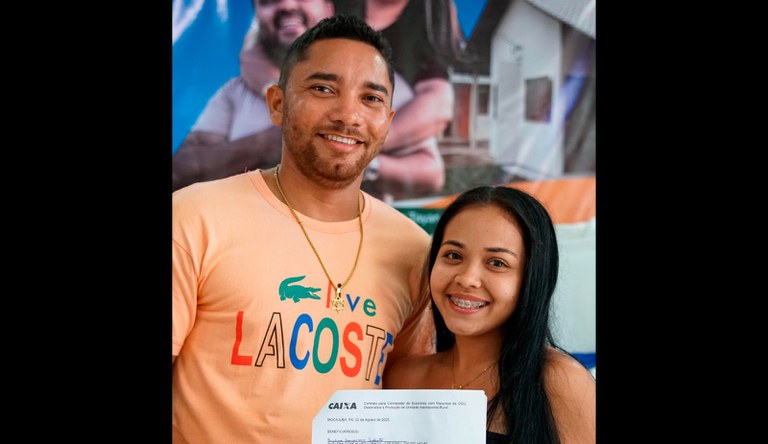 Casal com o contrato da casa pr´ópria do MCMV