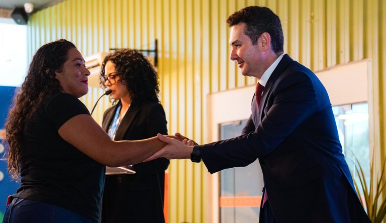 Homem cumprimenta mulher no evento do Minha Casa, Minha Vida