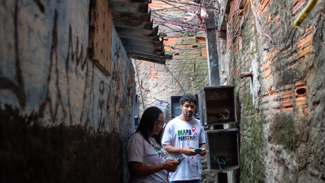 Um homem andando numa periferia de São Paulo 
