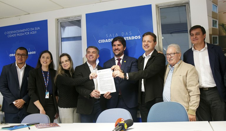 Na foto o secretário-executivo do Ministério das Cidades ao lado de outras autoridades com o contrato assinado.