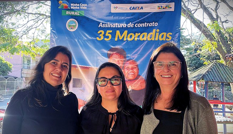 Três mulheres sorrindo para o fotógrafo