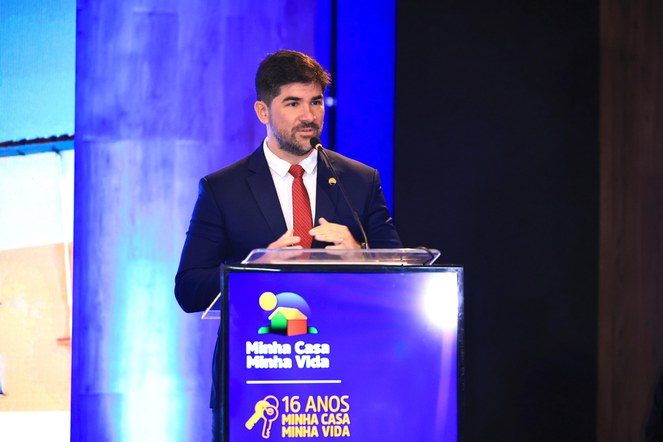 Homem no palanque falando sobre Minha Casa, Minha Vida 