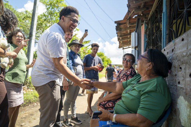 Homem cumprimenta moradores 