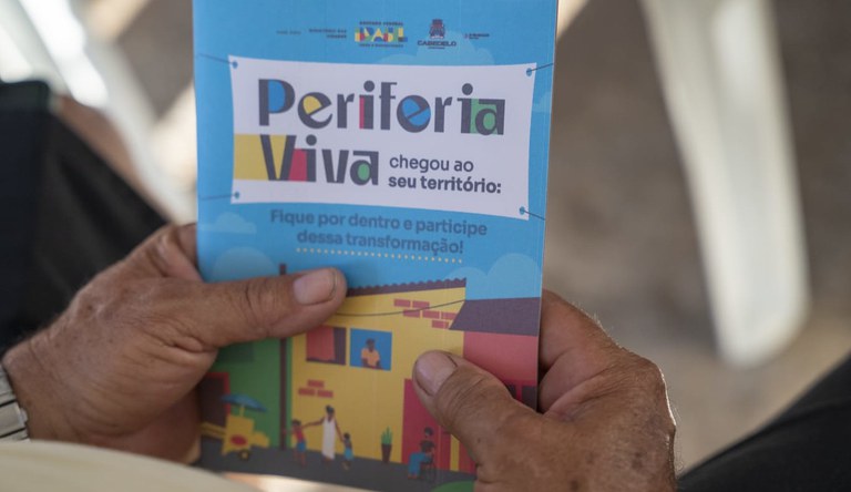 Homem segurando banner do Periferia Viva