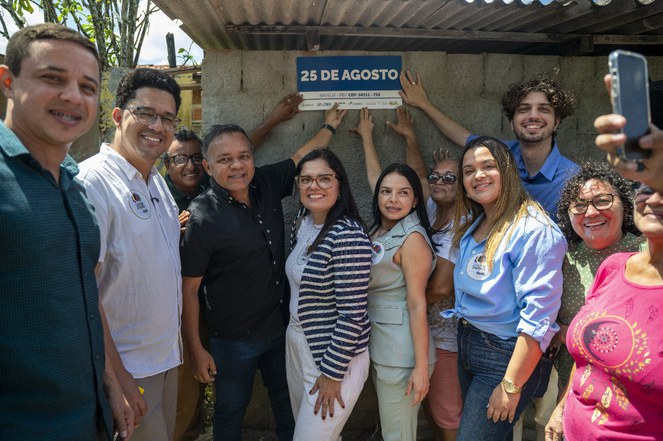 Na foto o secretário Nacional de Periferias junto a pessoas apontando a placa de CEP