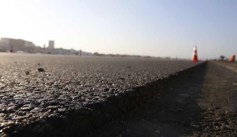 Na foto imagem rasante de uma rua asfaltada