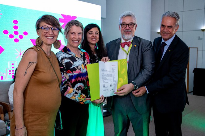 Pessoas segurando acordo Cidades Presentes