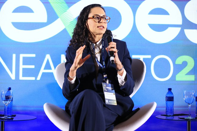 Mulher com microfone falando com a plateia