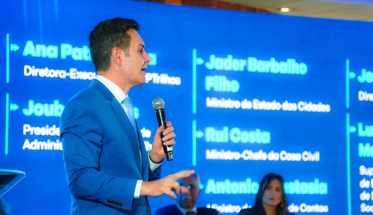 Homem com microfone falando em evento sobre mobilidade urbana