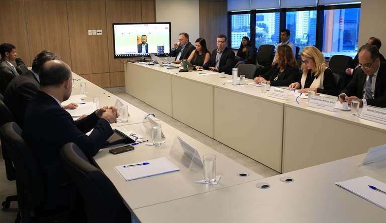 Na imagem grupo de pessoas sentadas em reunião sobre saneamento